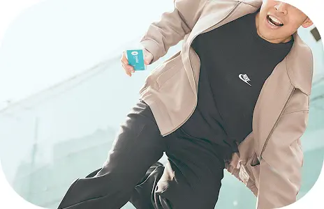 水色のモバイルバッテリーを持って柵をとび超えている男性